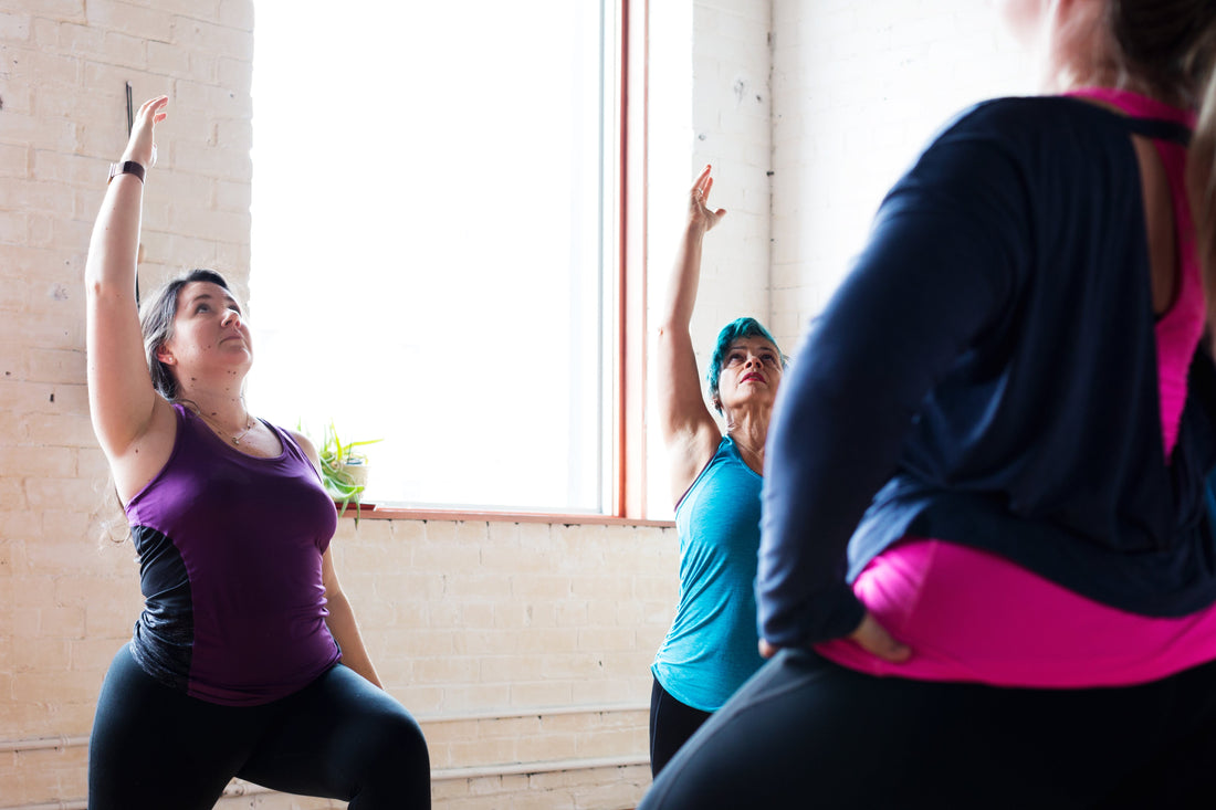 Beginners practicing yoga together, focusing on breath and movement rather than perfect poses.